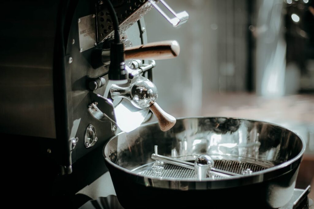 pexels-photo-31228819 Close-up of a shiny industrial coffee roaster in a cafe setting, highlighting details.